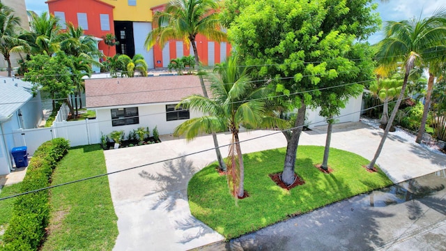 view of front of house featuring fence, a front lawn, and stucco siding