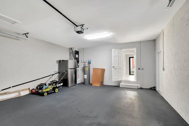 garage featuring concrete block wall, water heater, a garage door opener, and freestanding refrigerator