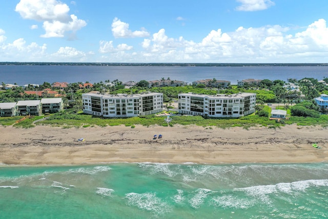 drone / aerial view with a water view and a beach view