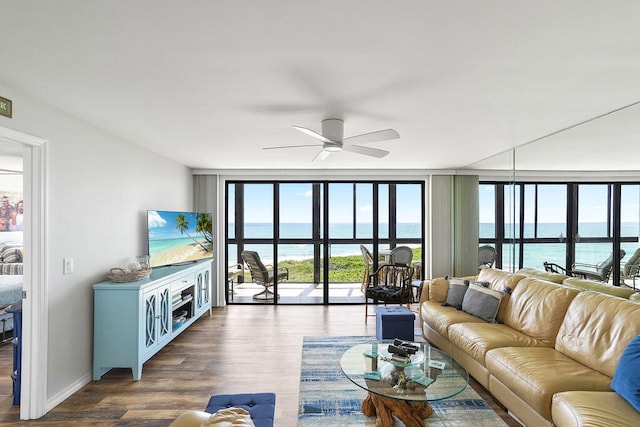 living room featuring hardwood / wood-style flooring, ceiling fan, and a wall of windows