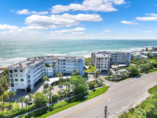 drone / aerial view featuring a beach view and a water view