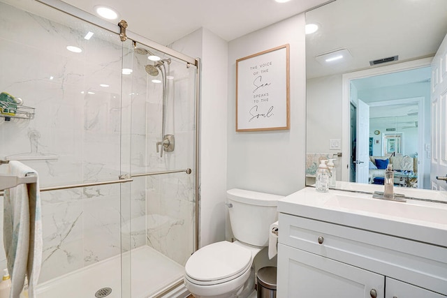 bathroom featuring vanity, toilet, and a shower with door