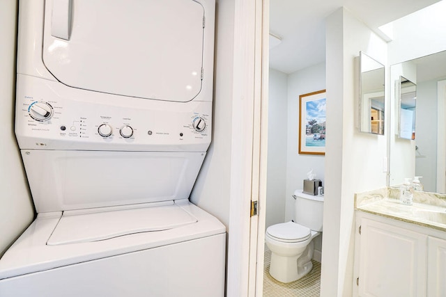 laundry room featuring tile patterned floors, sink, and stacked washer / drying machine