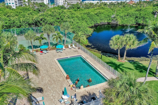 view of swimming pool featuring a water view and a patio