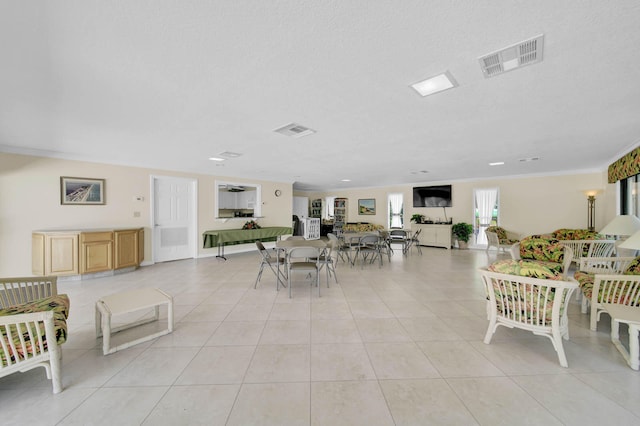 interior space with crown molding, a textured ceiling, and light tile patterned flooring