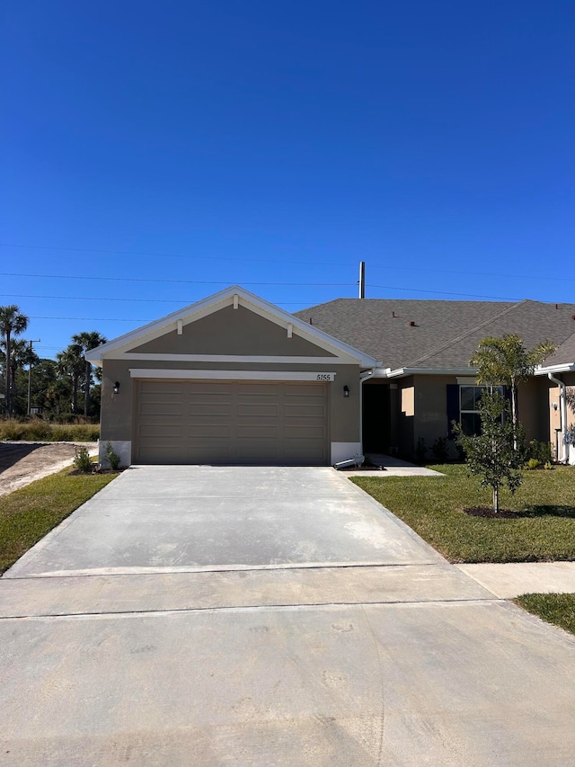 single story home with a front yard and a garage