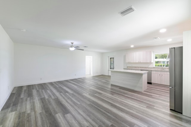 kitchen featuring a kitchen island, appliances with stainless steel finishes, ceiling fan, light wood-type flooring, and white cabinets