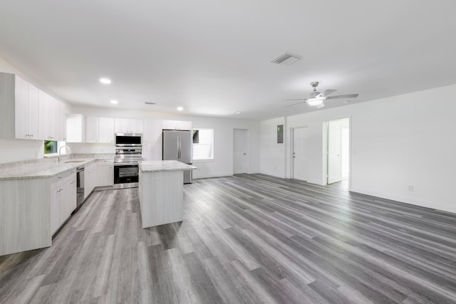 kitchen with a kitchen island, light hardwood / wood-style flooring, stainless steel appliances, ceiling fan, and white cabinets