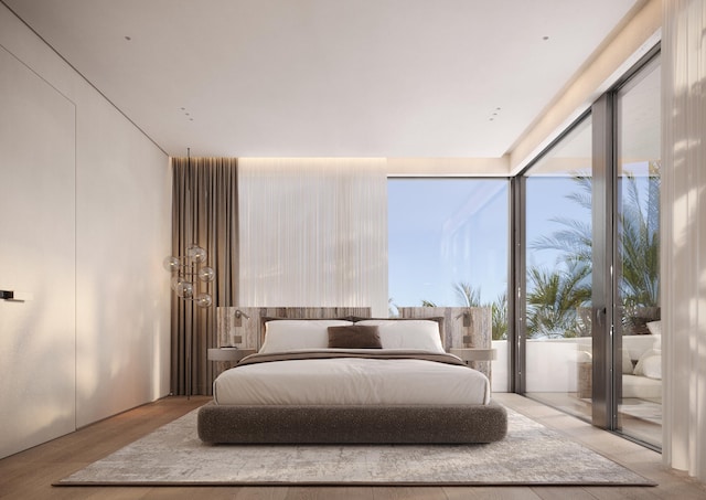 bedroom featuring light wood-type flooring, multiple windows, and access to outside