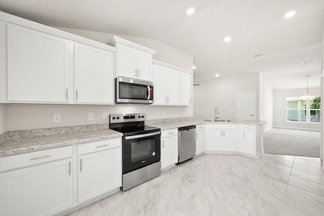 kitchen featuring lofted ceiling, white cabinets, sink, appliances with stainless steel finishes, and kitchen peninsula