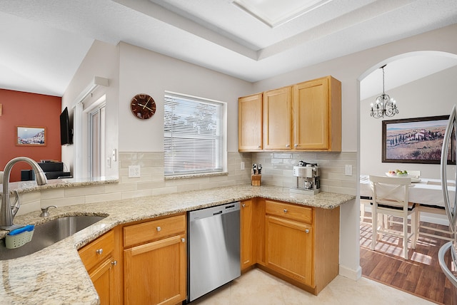 kitchen with backsplash, light wood-type flooring, dishwasher, pendant lighting, and sink