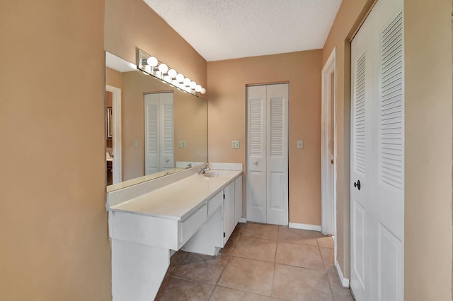 bathroom with vanity, a textured ceiling, and tile patterned floors