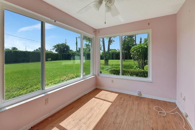 unfurnished sunroom with ceiling fan