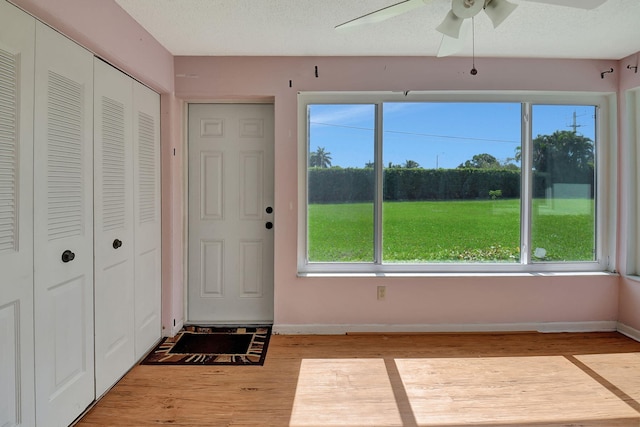 interior space featuring light hardwood / wood-style floors, ceiling fan, and a textured ceiling