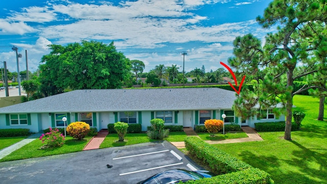 5020 Petal Pl Unit D, Delray Beach, FL 33484 - view of front of property featuring uncovered parking, a front lawn, and a shingled roof