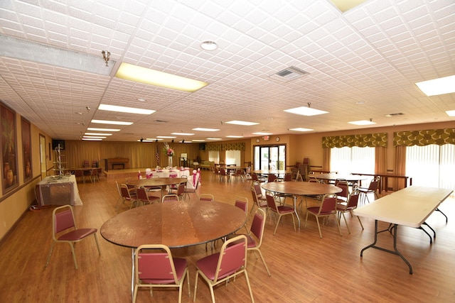 dining area featuring light wood-type flooring and wooden walls