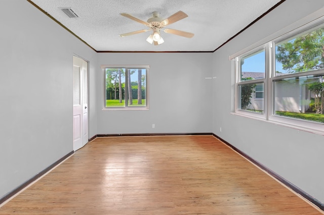 spare room featuring light hardwood / wood-style floors, ceiling fan, a textured ceiling, and ornamental molding