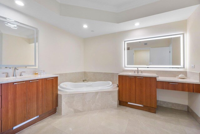 bathroom featuring vanity, a relaxing tiled tub, and crown molding