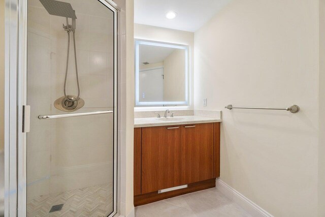 bathroom with tile patterned flooring, vanity, and an enclosed shower