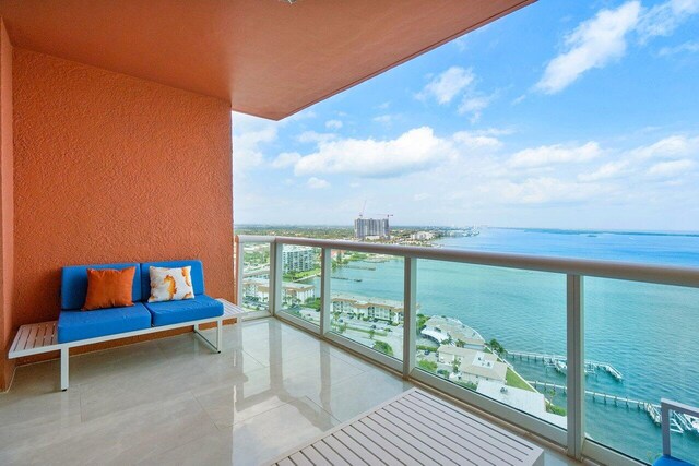 balcony featuring a water view and an outdoor living space