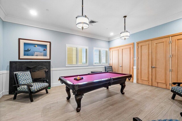 game room with crown molding, pool table, and light wood-type flooring