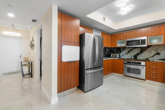 kitchen with tasteful backsplash, crown molding, appliances with stainless steel finishes, and pendant lighting