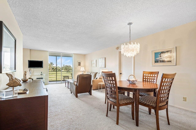 dining room with an inviting chandelier, a textured ceiling, and carpet floors