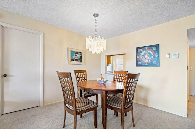 carpeted dining area with a textured ceiling and an inviting chandelier