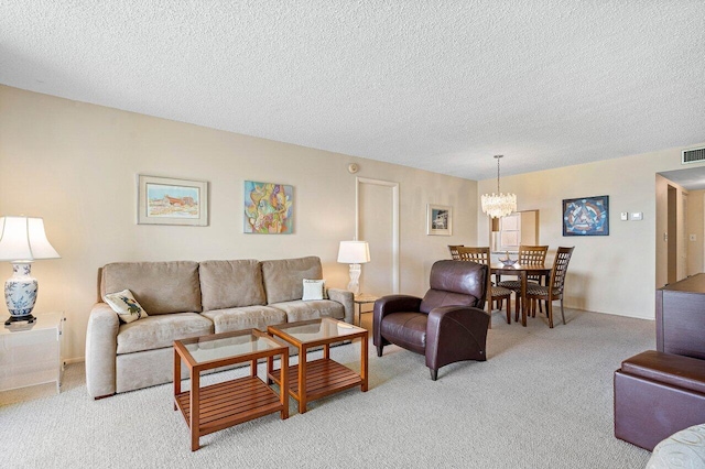 living room featuring a textured ceiling, light colored carpet, and a chandelier