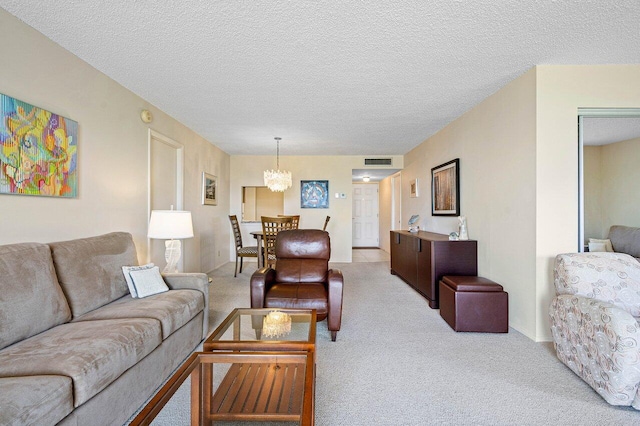 living room featuring a textured ceiling, light colored carpet, and an inviting chandelier