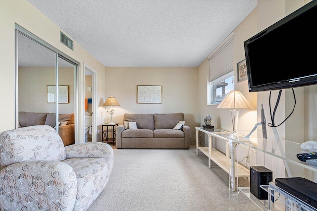 carpeted living room featuring a textured ceiling