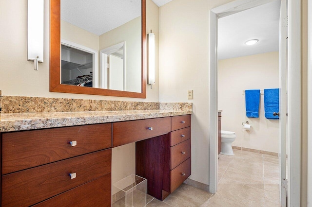 bathroom featuring a textured ceiling, vanity, toilet, and tile patterned floors