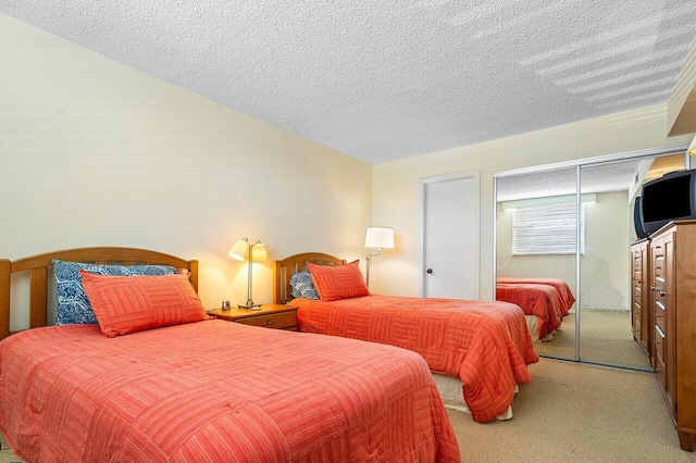 carpeted bedroom with a textured ceiling and a closet