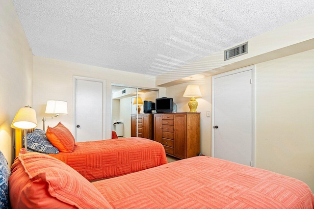 bedroom featuring a textured ceiling and a closet