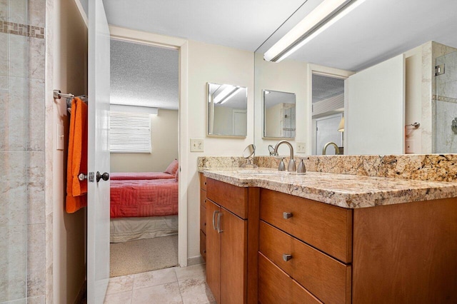 bathroom with a shower, tile patterned flooring, a textured ceiling, and vanity