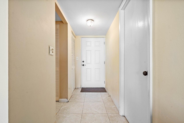 corridor featuring baseboards and light tile patterned floors