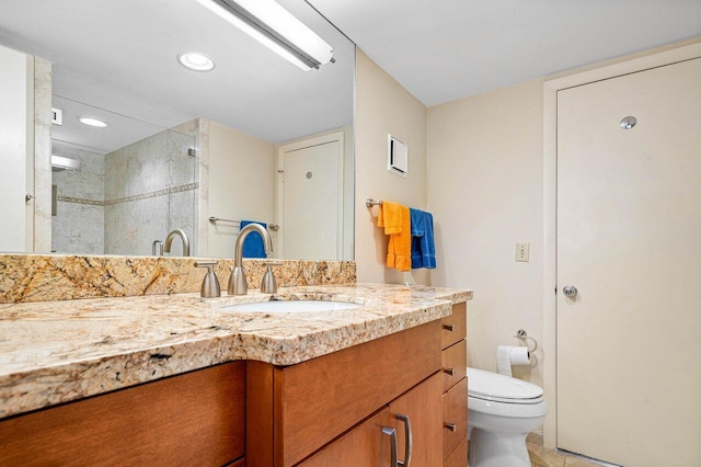 bathroom with vanity, toilet, tile patterned floors, and a tile shower