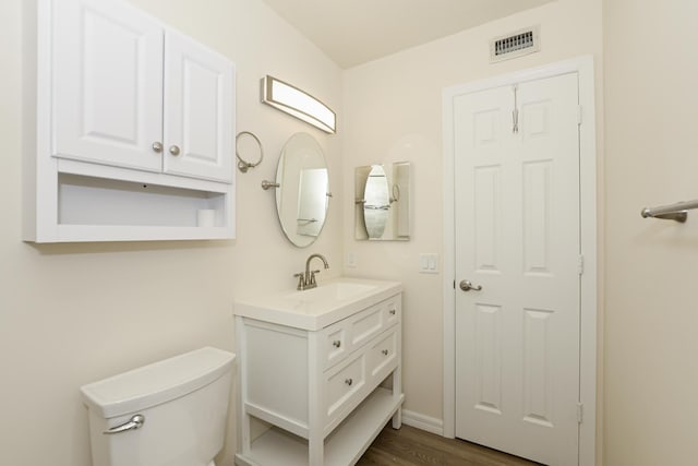 bathroom featuring hardwood / wood-style flooring, vanity, and toilet