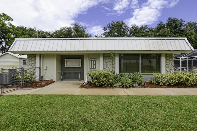 view of front facade with a front yard and cooling unit