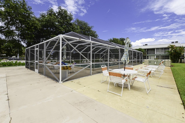 view of patio featuring glass enclosure