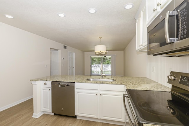 kitchen with white cabinets, appliances with stainless steel finishes, light hardwood / wood-style floors, and sink