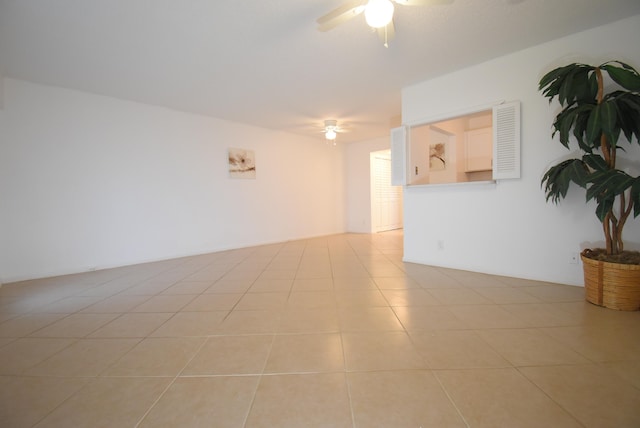 tiled empty room featuring ceiling fan