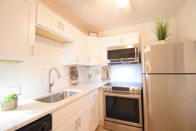 kitchen featuring white cabinetry, stainless steel appliances, sink, ceiling fan, and decorative backsplash