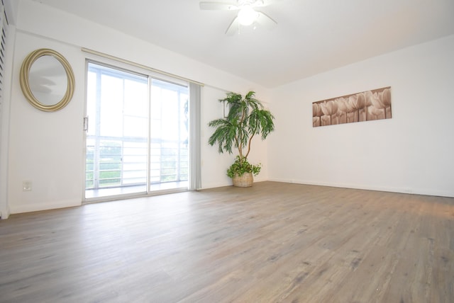 spare room with a healthy amount of sunlight, ceiling fan, and hardwood / wood-style floors