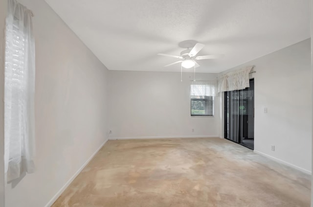 empty room featuring ceiling fan and light carpet