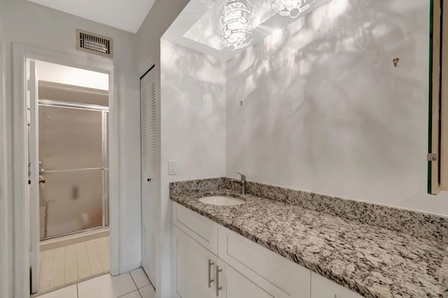 bathroom with tile patterned flooring, vanity, and a shower with shower door