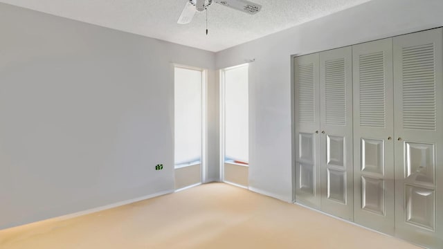 unfurnished bedroom with ceiling fan, a closet, carpet, and a textured ceiling