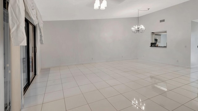 empty room with a notable chandelier, high vaulted ceiling, and light tile patterned flooring