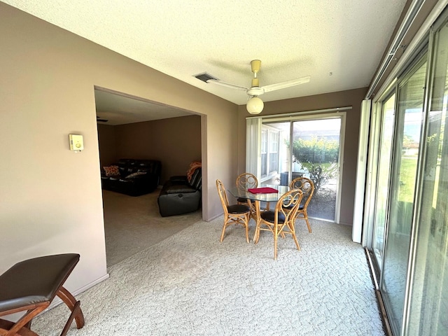 dining room with a textured ceiling, carpet, and ceiling fan