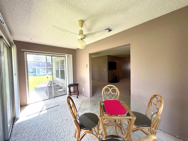 carpeted dining room featuring a textured ceiling and ceiling fan